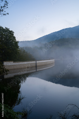 Santa Fe del Montseny Reservoir at dusk with mist and reflection in the water, Catalonia, Spain