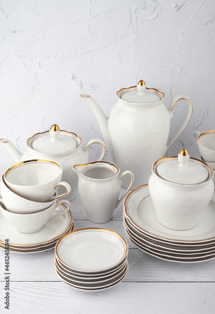 White tea set on a white background. Teapot, cream, sugar bowl, cups, saucers, plates on the table. Porcelain dishes. For six persons.
White tea set on a white background. Teapot, cream, sugar bowl, cups, saucers, plates on the table. Porcelain dishes. For six persons.