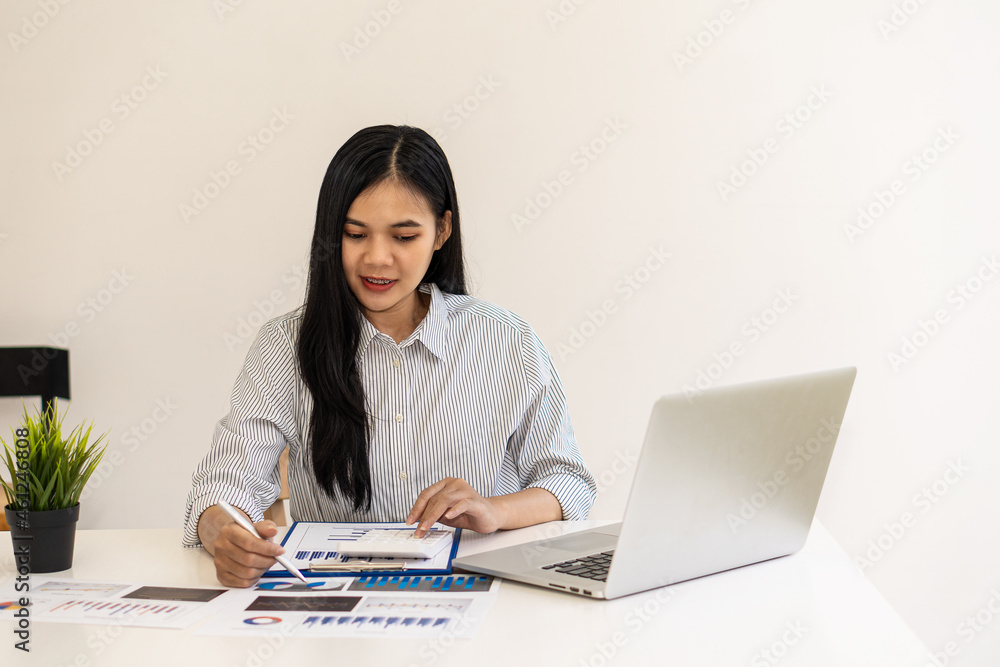 Businesswoman analyzing and brainstorming data, charts, financial reports in the office with laptop and calculator. Ideas for working with financial and investment accounts. Businesswoman analyzing and brainstorming data, charts, financial reports in the office with laptop and calculator. Ideas for working with financial and investment accounts.