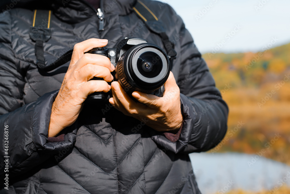 Senior people and technology, retirement hobby, tourism concept. Close-up of elderly woman's hand holding digital camera, pensioner photographer or tourist standing outdoors on autumn day Senior people and technology, retirement hobby, tourism concept. Close-up of elderly woman's hand holding digital camera, pensioner photographer or tourist standing outdoors on autumn day