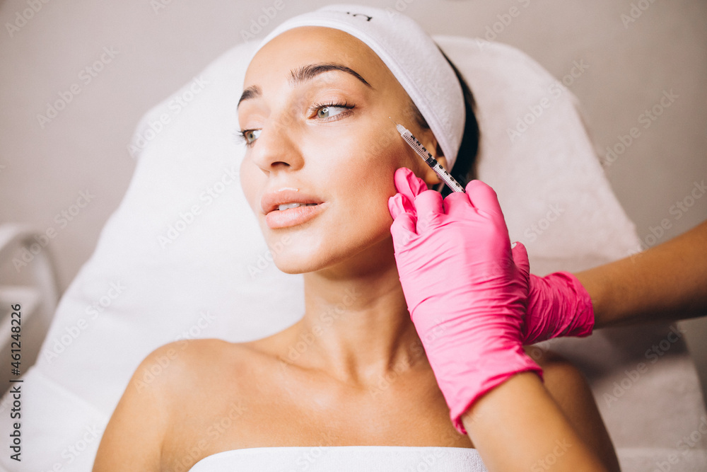 Cosmetologist making injections on a face of a woman in a beauty salon