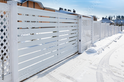 Fototapeta sliding plastic gates for the entrance of a car in a suburban village