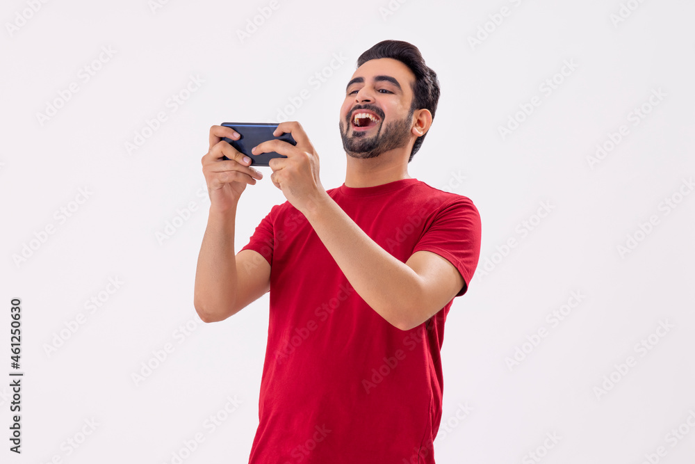 A MAN ENTHUSIASTICALLY PLAYING VIDEO GAME ON MOBILE A MAN ENTHUSIASTICALLY PLAYING VIDEO GAME ON MOBILE