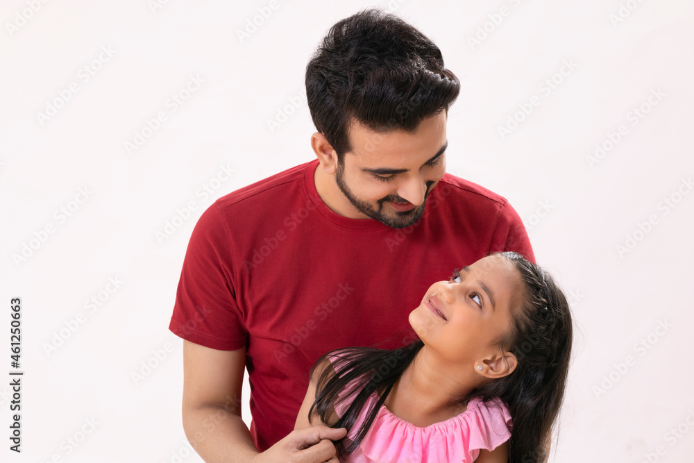 A HAPPY FATHER AND DAUGHTER STANDING AND LOOKING AT EACH OTHER A HAPPY FATHER AND DAUGHTER STANDING AND LOOKING AT EACH OTHER