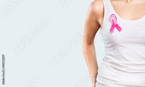 Young woman showing pink ribbon symbolizing breast cancer