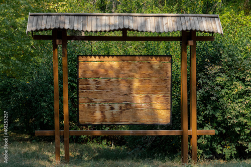 Wooden rectangular board from bars background for ads, against the backdrop of greenery in the recreation park