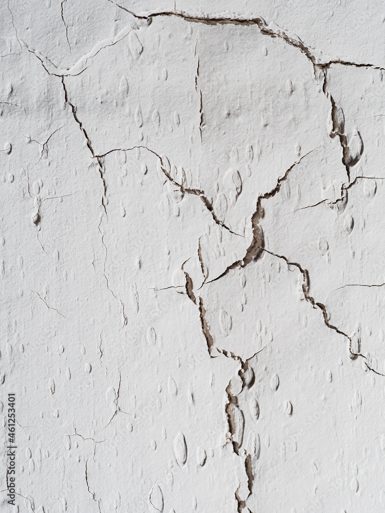 Obraz premium many cracks on the light wall. Textured background. Vertical