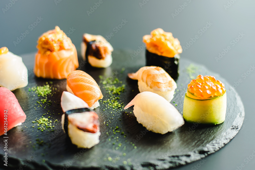Maki and nigiri sushi variety with salmon, shrimp, avocado and tuna at a sushi restaurant Maki and nigiri sushi variety with salmon, shrimp, avocado and tuna at a sushi restaurant