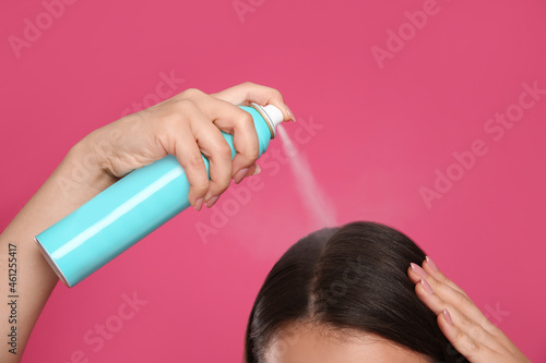 Wallpaper Mural Young woman applying dry shampoo against pink background, closeup Torontodigital.ca