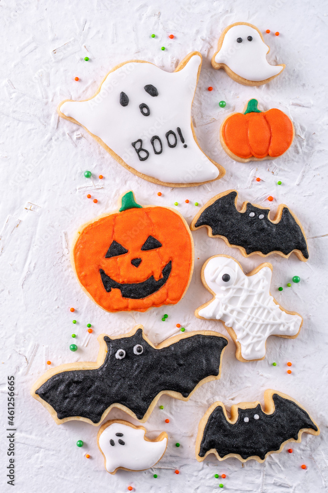 Top view of Halloween festive decorated icing sugar cookies on white background.