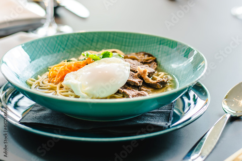 Beef ramen soup with poached egg and vegetables at a restaurant