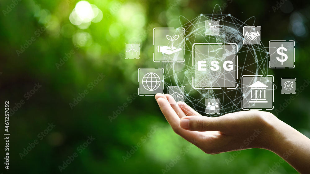 ESG icon concept in the hand for environmental, social, and governance in sustainable and ethical business on the Network connection on a green background. - obrazy, fototapety, plakaty 