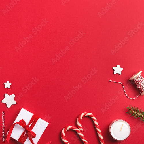 Red Christmas square frame with winter holiday decor on red background. Top view, copy space.