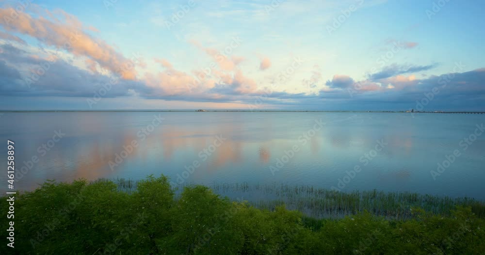 Beautiful summer sunset reflecting from the calm sea surface in panoramic photo Beautiful summer sunset reflecting from the calm sea surface in panoramic photo