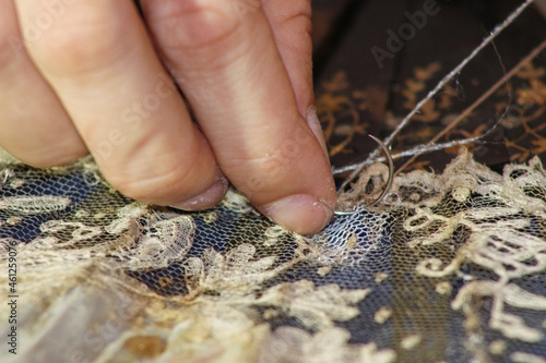Foto Person sewing restoring an old piece of textile