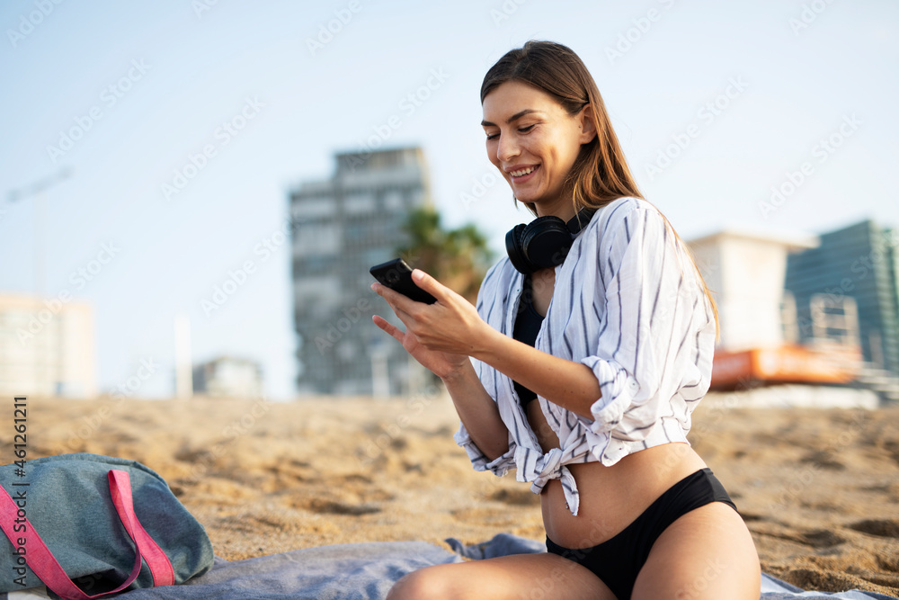 Happy young woman relaxing on the sandy beach. Beautiful woman enjoying a summer day on the beach.