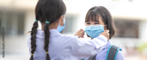 Children students in student uniform wearing protective face mask for each other to go to school after COVID-19 pandemic situation getting better. Back to School Concept Stock Photo