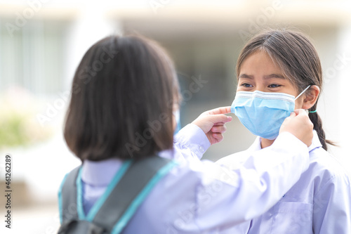 Children students in student uniform wearing protective face mask for each other to go to school after COVID-19 pandemic situation getting better. Back to School Concept Stock Photo