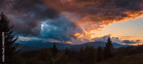 Fascinating summer sunset and heavy clouds over high mountains