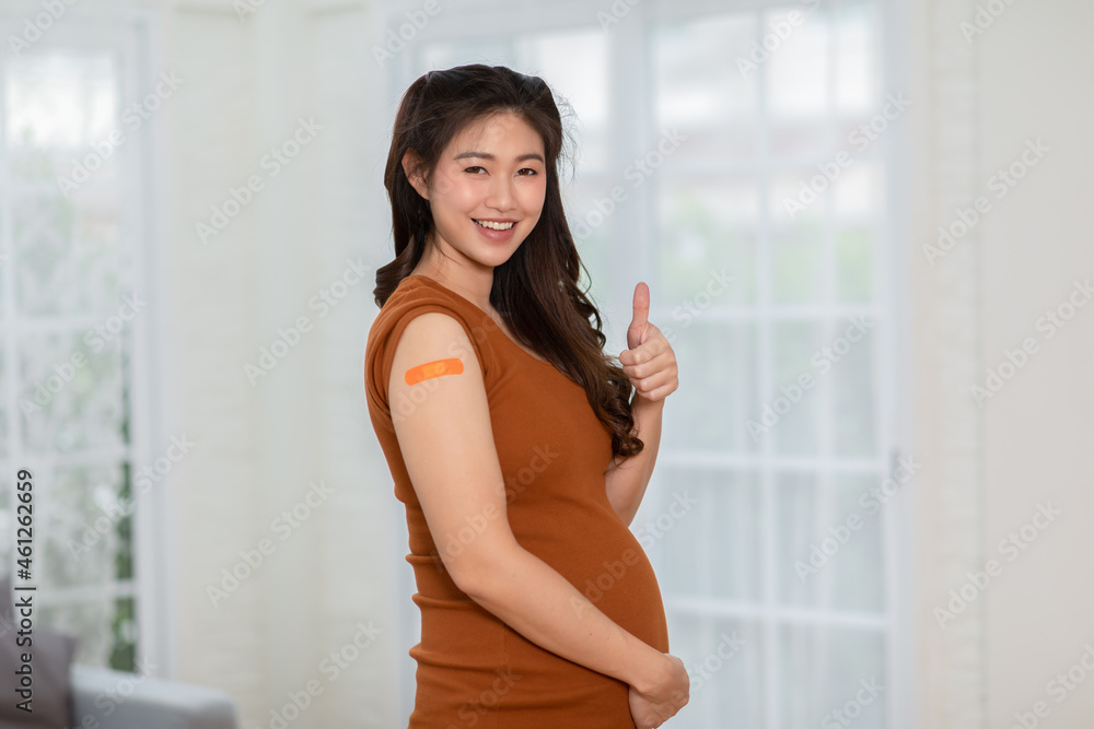 Happy Pregnant Asian Woman received anti virus vaccine cheerful with bandage,Pregnancy of young woman enjoying with future safety life after got COVID-19 vaccination,vaccination in Pregnant Concept