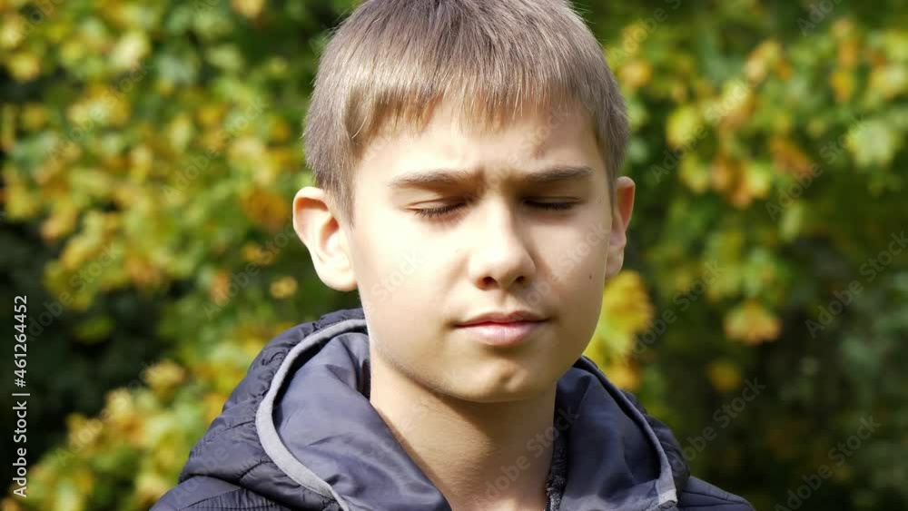Teenage boy in black jacket looking arround in park outdoors. Kid turn his head and looking direct to camera. 4K footage video Teenage boy in black jacket looking arround in park outdoors. Kid turn his head and looking direct to camera. 4K footage video