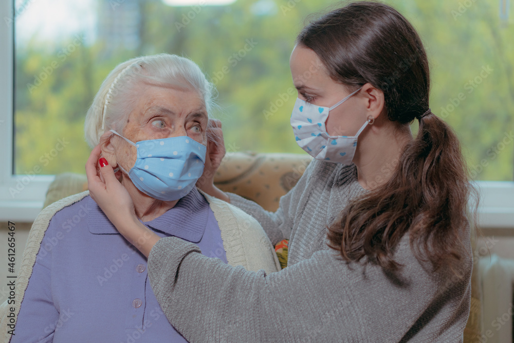 Medical mask. The granddaughter adjusts a medical mask on her face.