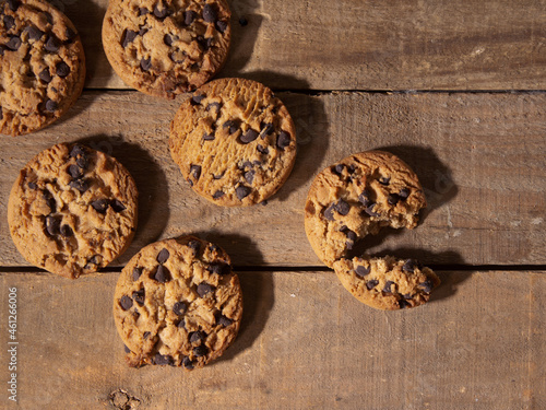 top view of handmade chocolate chip cookies on antique dark wood background
