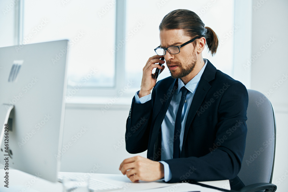 man in a suit sitting at a desk in front of a computer Chief man in a suit sitting at a desk in front of a computer Chief