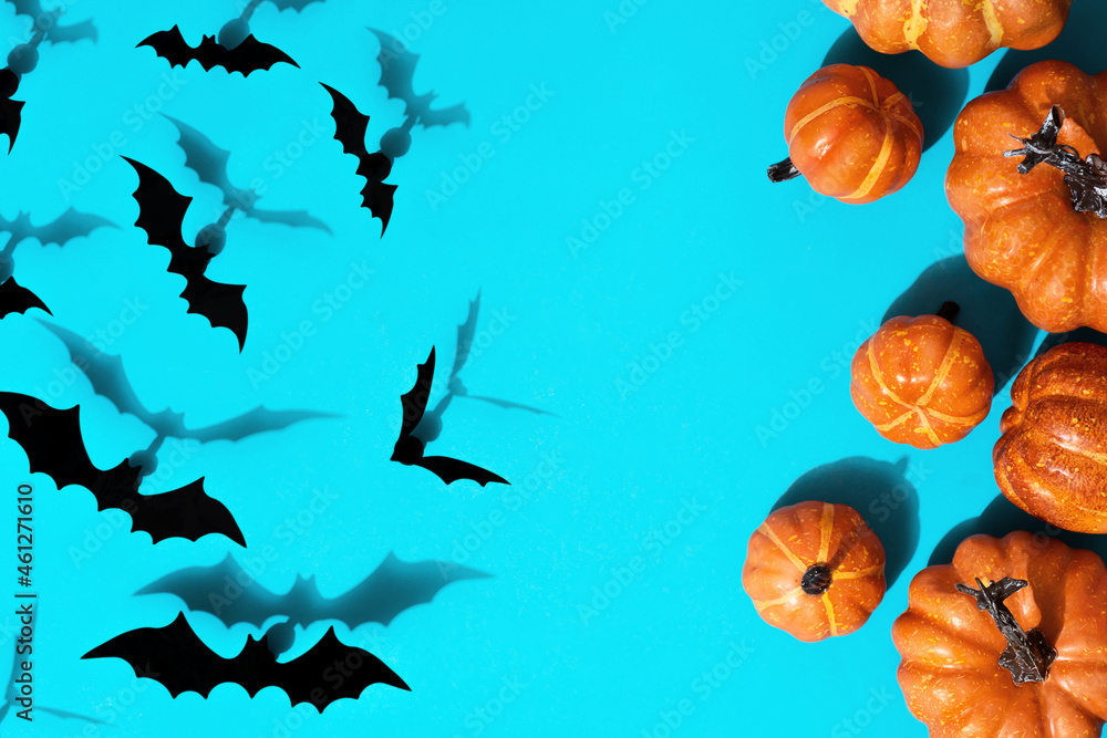 Halloween holiday concept. Pattern from paper bats of pumpkins and decor. Flat lay on blue background with copy space. Halloween holiday concept. Pattern from paper bats of pumpkins and decor. Flat lay on blue background with copy space.