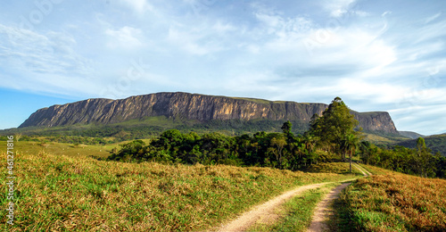 Panorama of the large rock wall  of the Serra da Canastra park massif  with forest and pastures  sunny day and blue sky with clouds  S  o Roque de Minas  Minas Gerais  Brazil