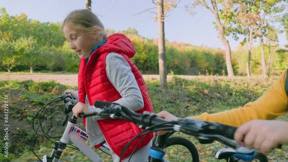 children walking in the autumn forest with bicycles children walking in the autumn forest with bicycles