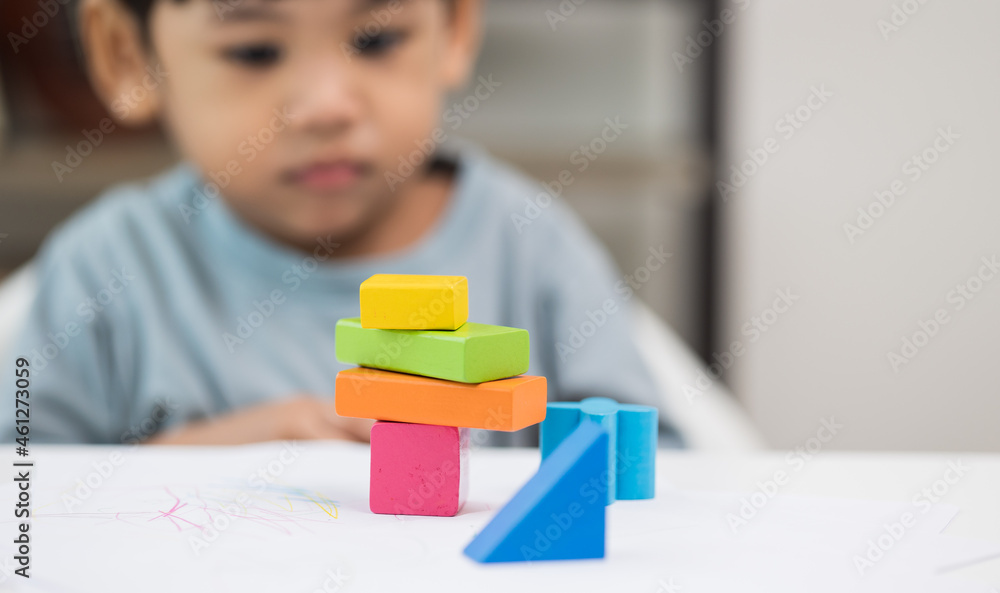 Close up Children hand Practice the skills of playing with wooden toys on the table in living room. Asian little boy education from home. Developing children's learning before entering kindergarten Close up Children hand Practice the skills of playing with wooden toys on the table in living room. Asian little boy education from home. Developing children's learning before entering kindergarten
