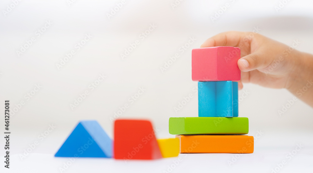 Close up Children hand Practice the skills of playing with wooden toys on the table in living room. Asian little boy education from home. Developing children's learning before entering kindergarten Close up Children hand Practice the skills of playing with wooden toys on the table in living room. Asian little boy education from home. Developing children's learning before entering kindergarten