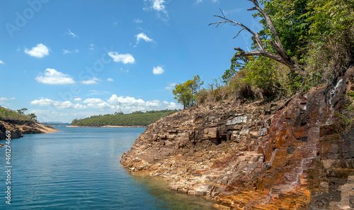 Rocky walls, with vegetation on top, of the canyons of the huge lake of the Furnas dam, blue sky with clouds, Capitolio, Minas Gerais, Brazil