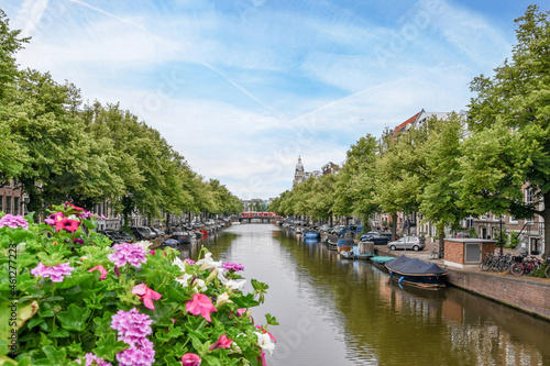 Various boats moored on canal flowing in city district photo