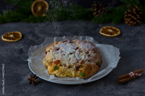 Christmas Stollen against the background of spruce branches and gray concrete
