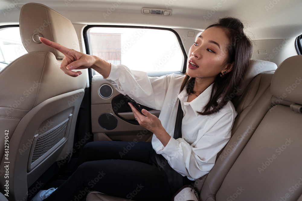 Asian woman explaining way to taxi driver Asian woman explaining way to taxi driver