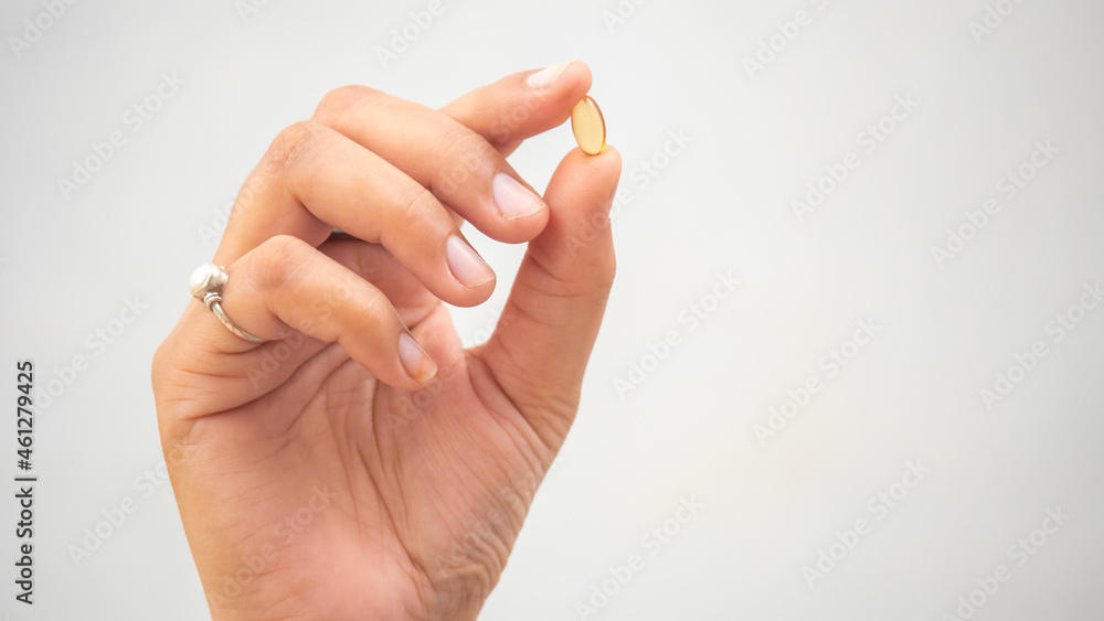 Girl holding Yellow Soft Vitamin Gel Pill Girl holding Yellow Soft Vitamin Gel Pill