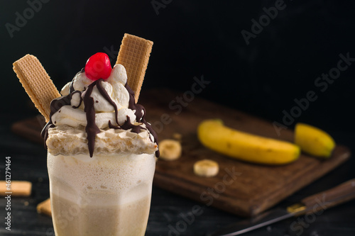 Yummy milkshake topped with cream and waffles photo
