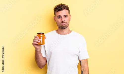 young handsome man feeling sad and whiney with an unhappy look and crying. peach jelly concept photo