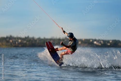 Teenage boy wakeboarding on river. Extreme water sport photo