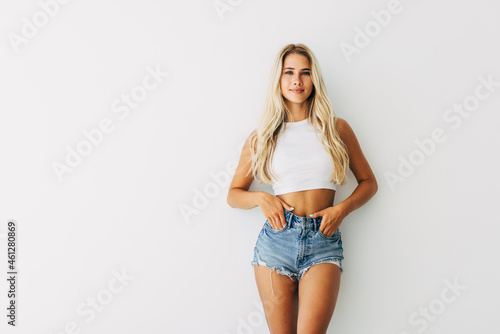 Fotótapéta Smiling young blond hair woman holding hands on hips and looking at camera while