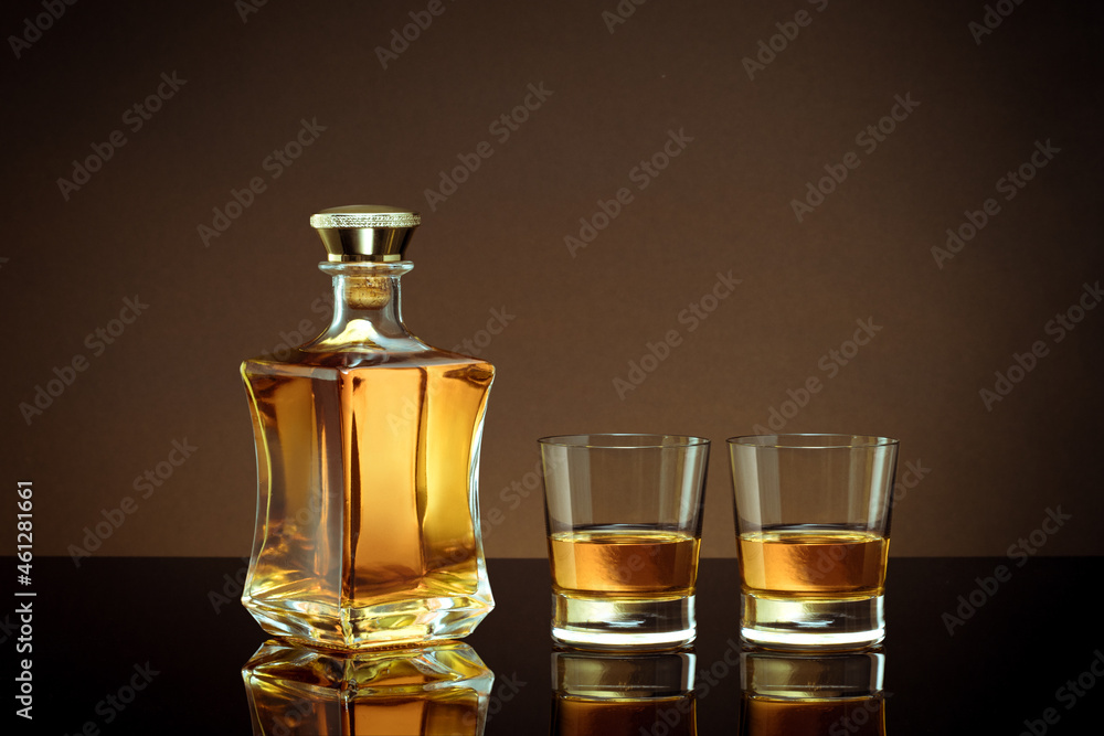close up view of bottle of whiskey and two glasses aside on color back.  - obrazy, fototapety, plakaty 