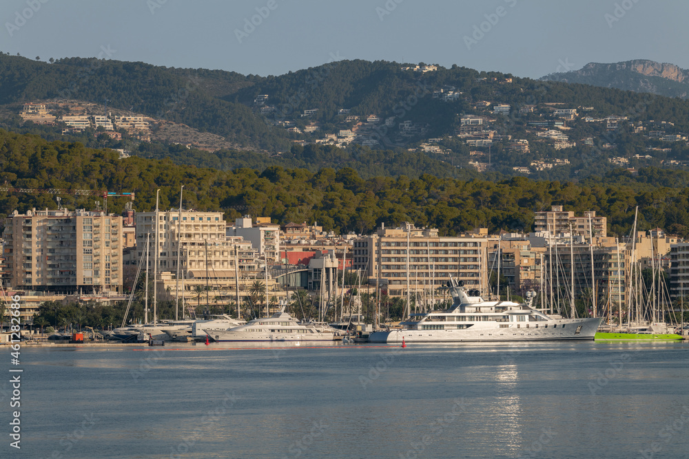 Early morning view of the city of Palma de Mallorca. Large yachts are on the quay. In the background is the city and the mountains of the Mediterranean island.