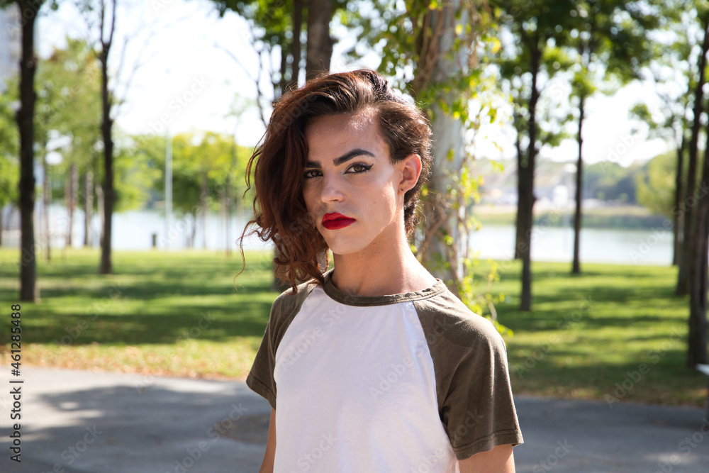 young latina transsexual woman is in a park where she is going to start doing her make-up for her big change from boy to girl. Concept of diversity, transgender, and freedom of homosexual expression. - obrazy, fototapety, plakaty 