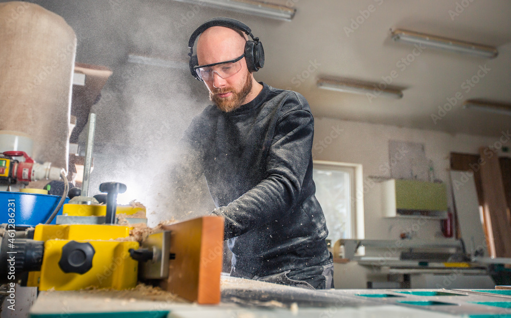 Carpenter working on woodworking saw machines in carpentry shop, industrial concept Carpenter working on woodworking saw machines in carpentry shop, industrial concept
