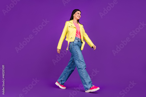 Profile side photo of young millennial lady walk empty space stylish outfit isolated over violet color background