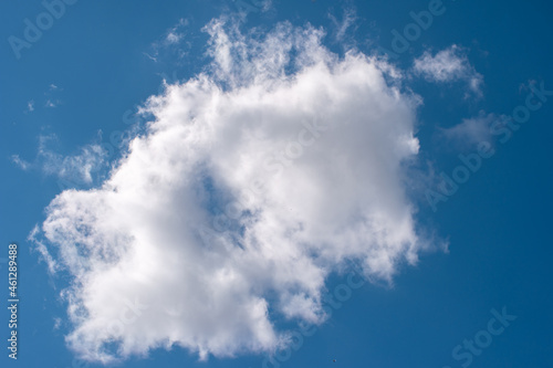 Puffy white cloud on blue summer sky