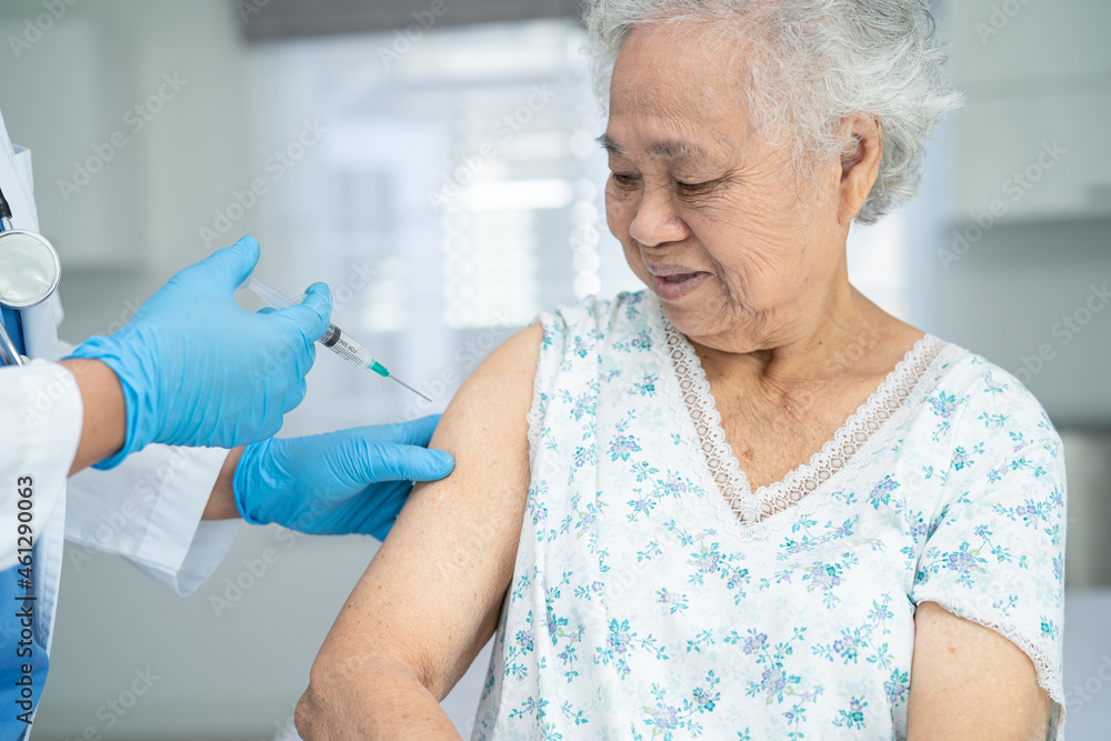 Elderly Asian senior woman wearing face mask getting covid-19 or coronavirus vaccine by doctor make injection. Elderly Asian senior woman wearing face mask getting covid-19 or coronavirus vaccine by doctor make injection.