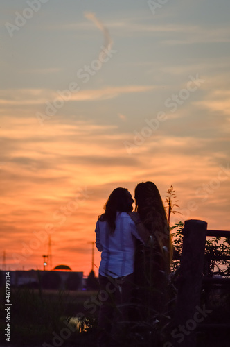 Silhouette of a young loving couple kissing at sunset, in the countryside in autumn